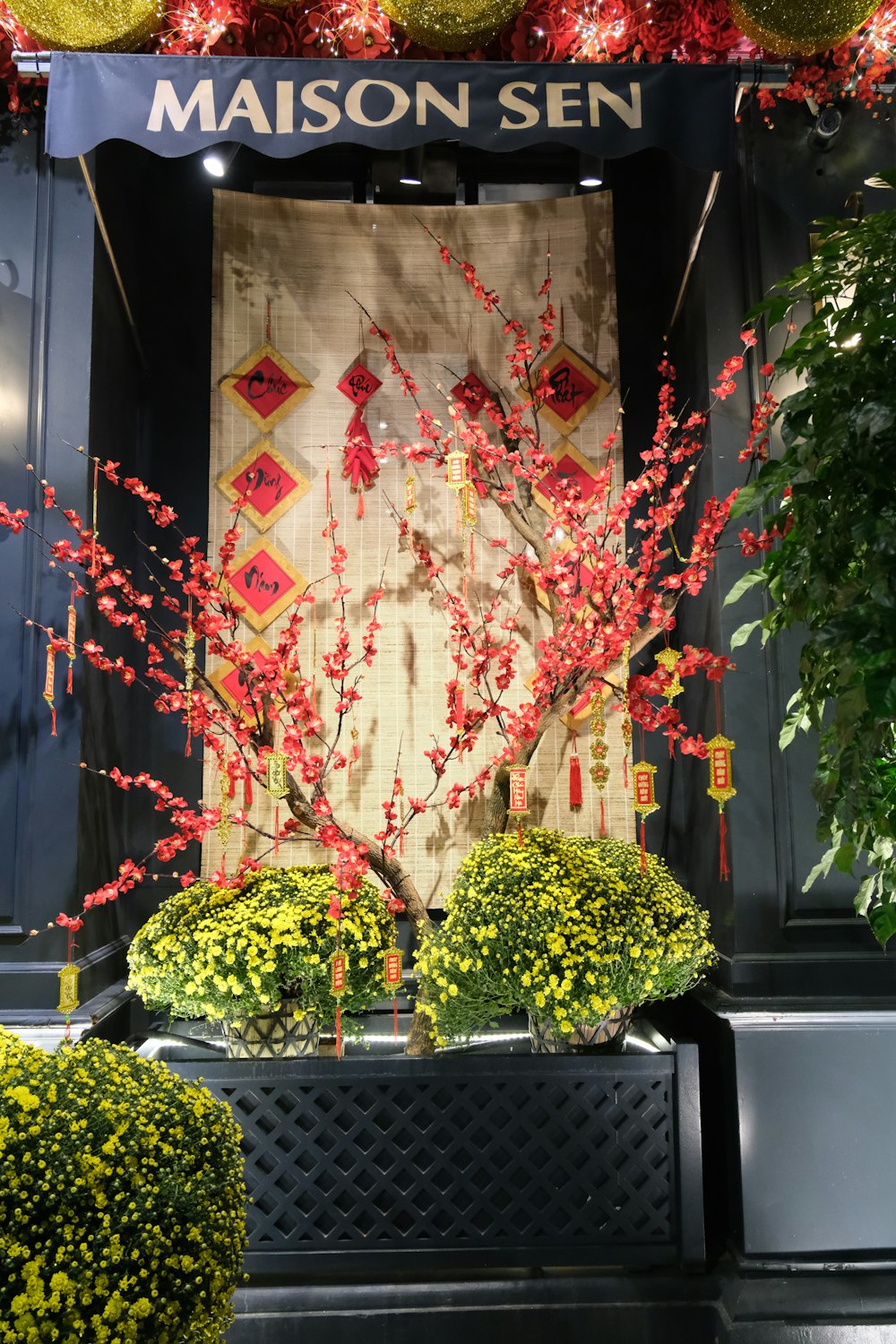 a display of red and yellow flowers in front of a store window
