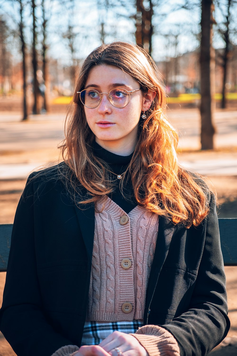 a woman sitting on a bench in a park