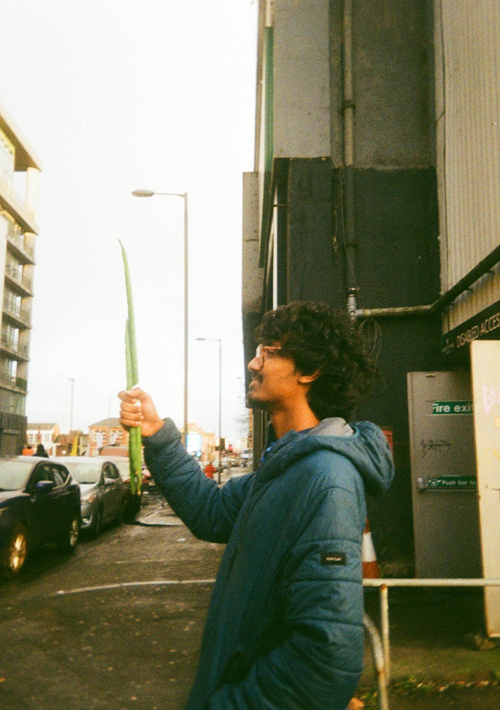 a man standing on the side of a road holding a kite