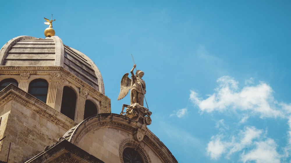 a statue of an angel on top of a building