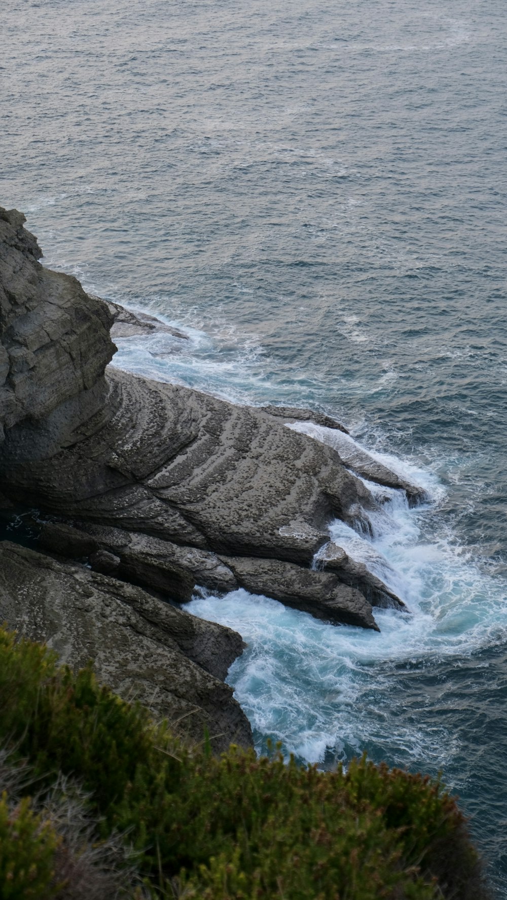 a person standing on top of a cliff next to the ocean