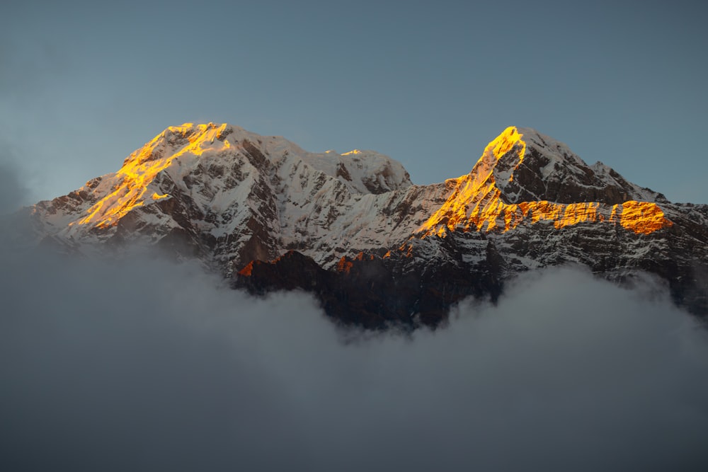 a mountain covered in snow with a yellow light on it