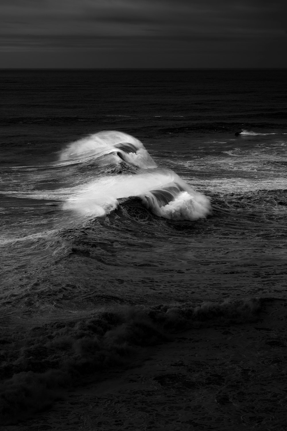 Uma foto em preto e branco das ondas no oceano