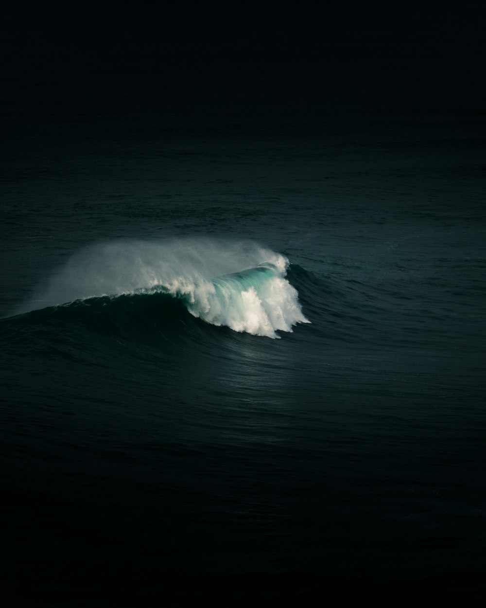 a large wave in the middle of the ocean