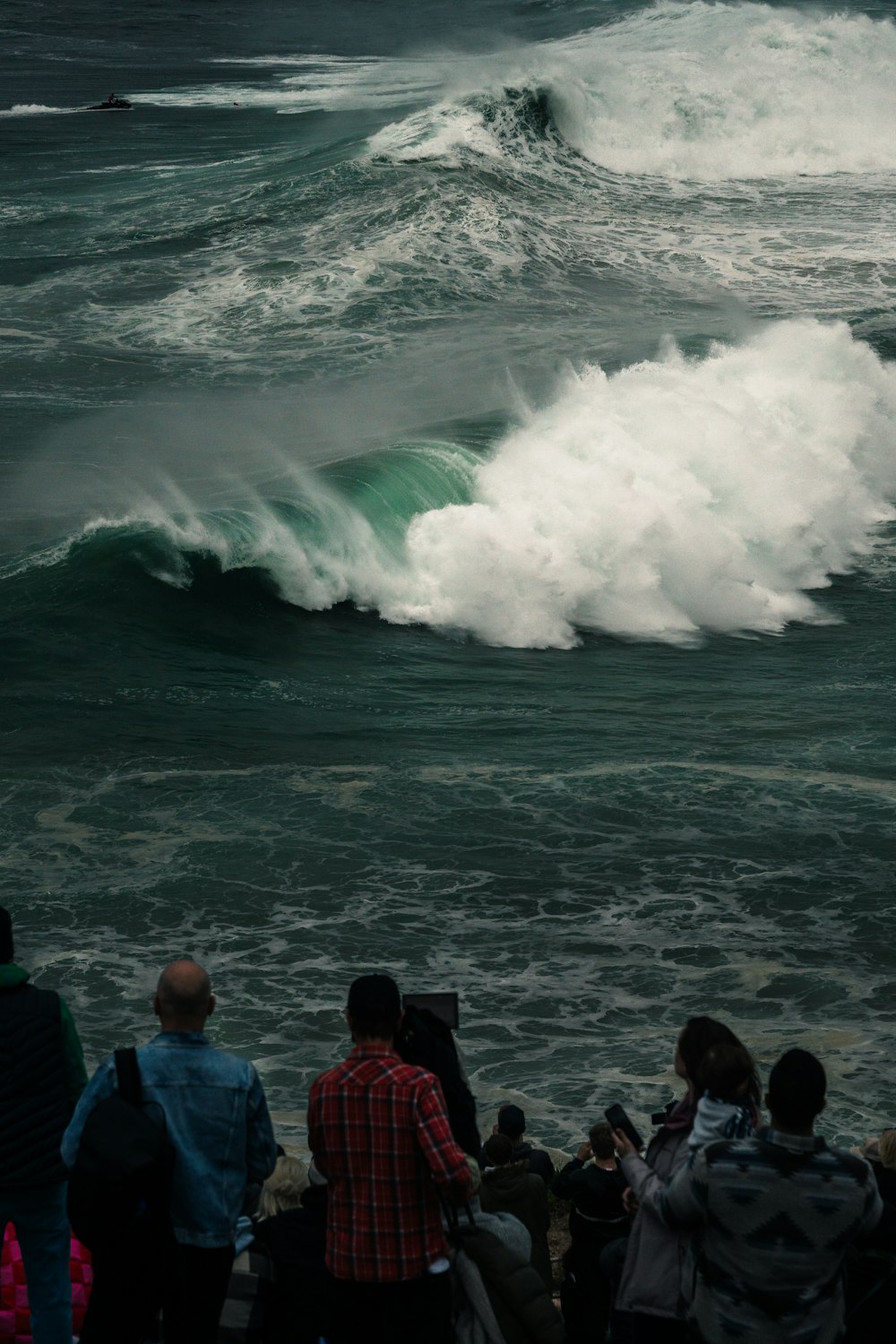 a group of people looking at a large wave