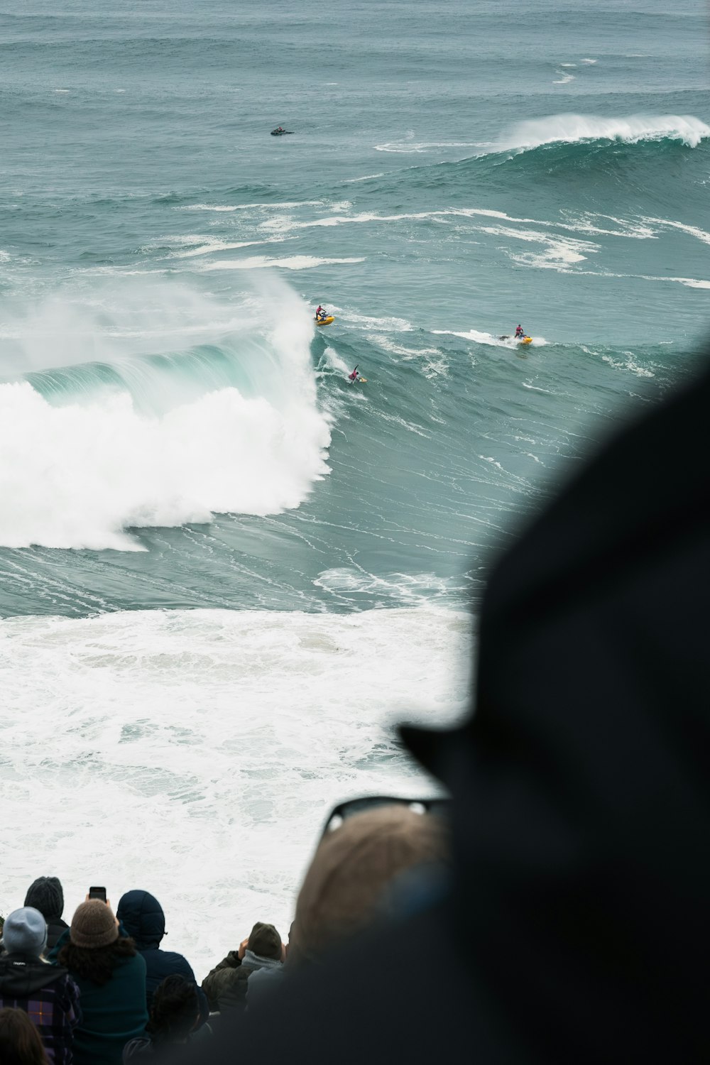 a group of people watching a surfer ride a wave