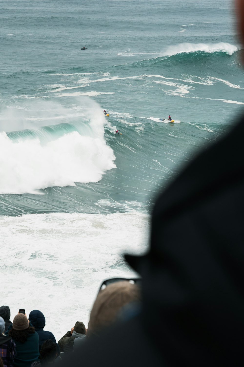 a group of people watching a surfer ride a wave