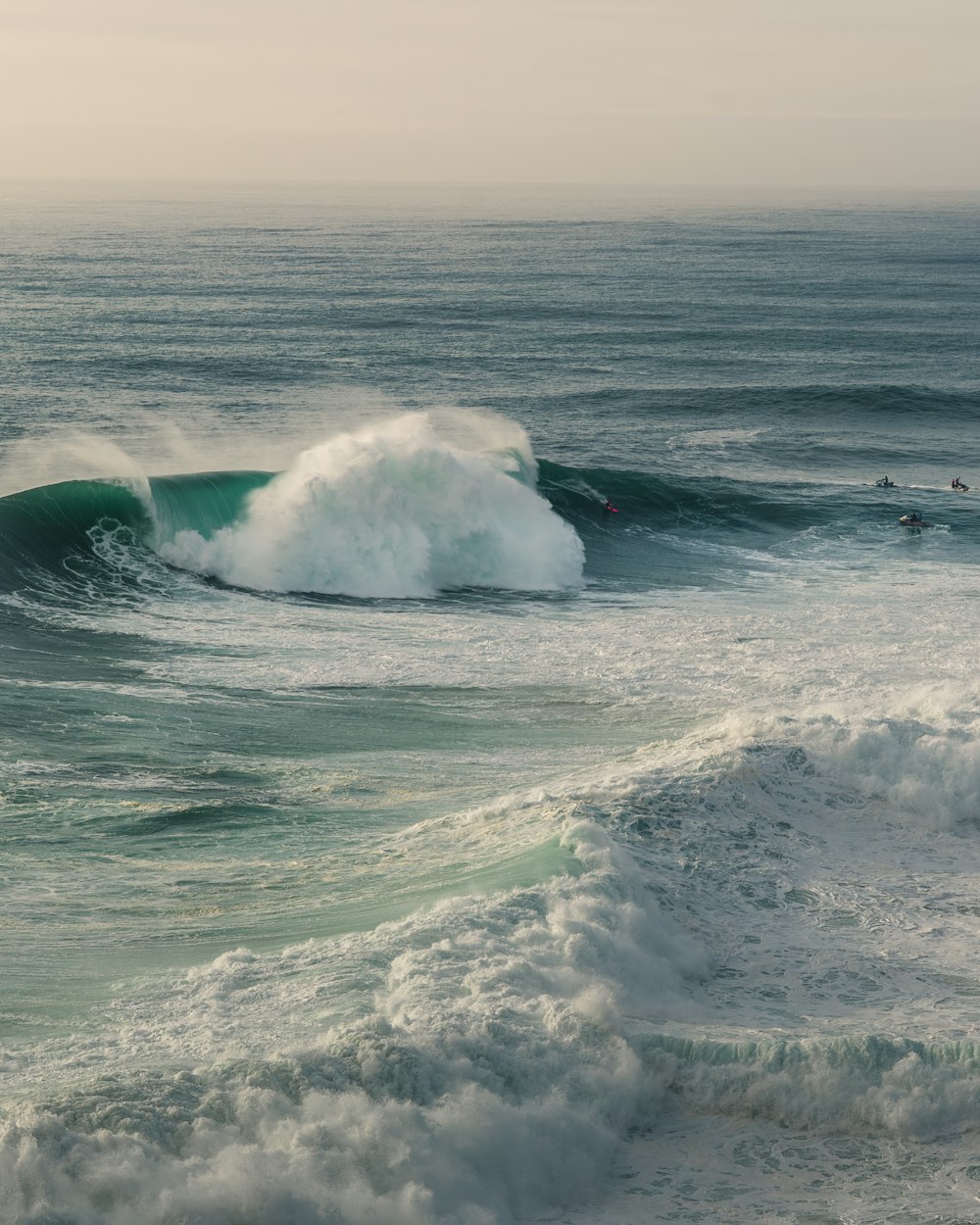 a large wave crashing into the shore of the ocean