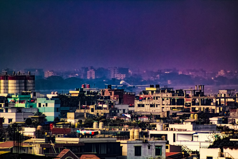 a view of a city with a plane in the sky