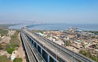 an aerial view of a highway with a bridge in the background