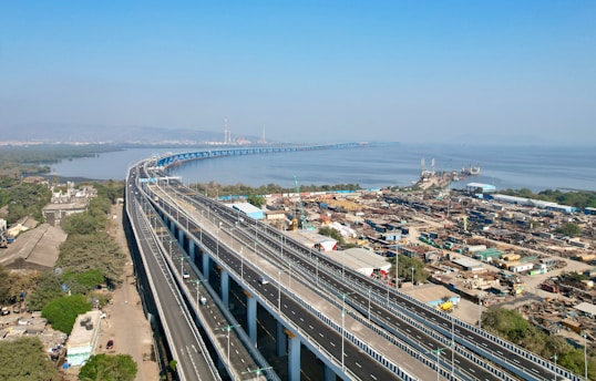 an aerial view of a highway with a bridge in the background