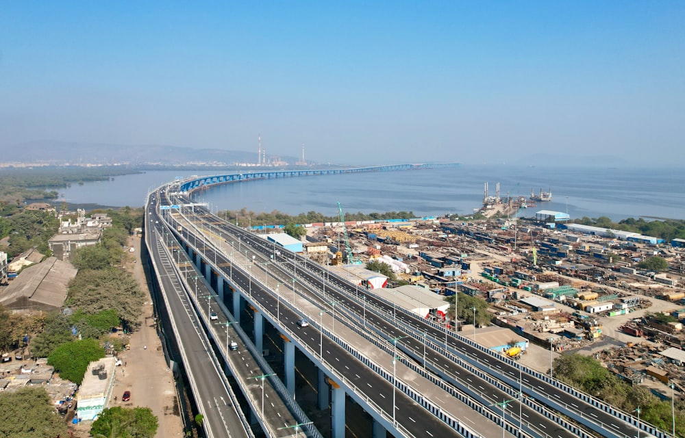 an aerial view of a highway with a bridge in the background