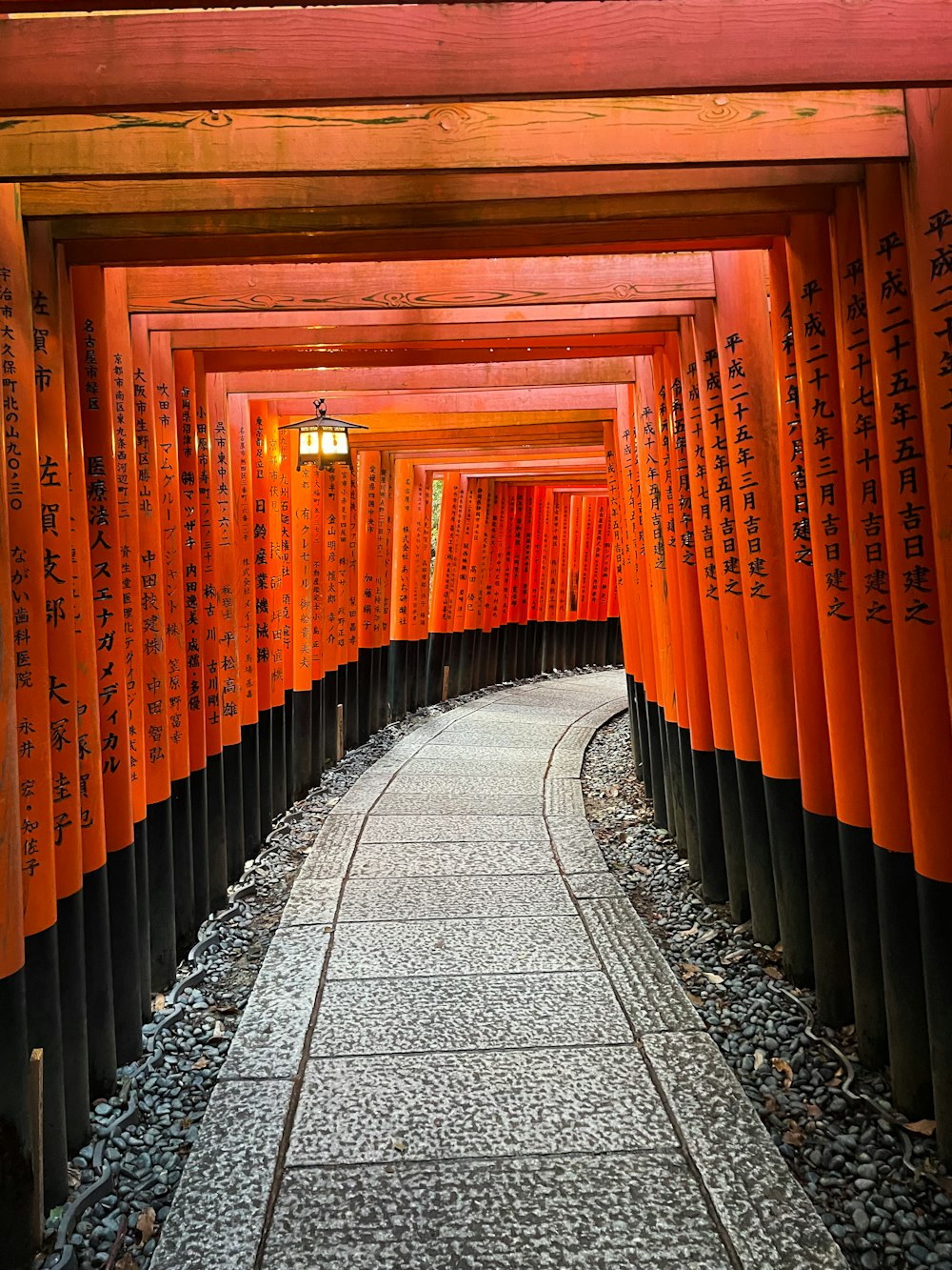 a walkway lined with orange and black columns