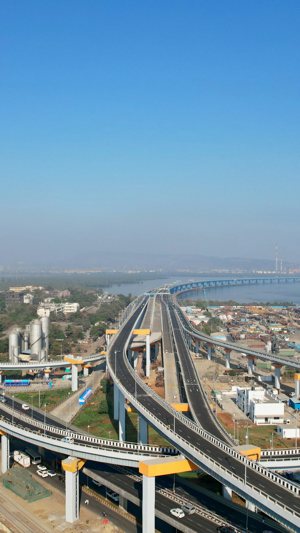 an aerial view of a highway with a bridge in the background