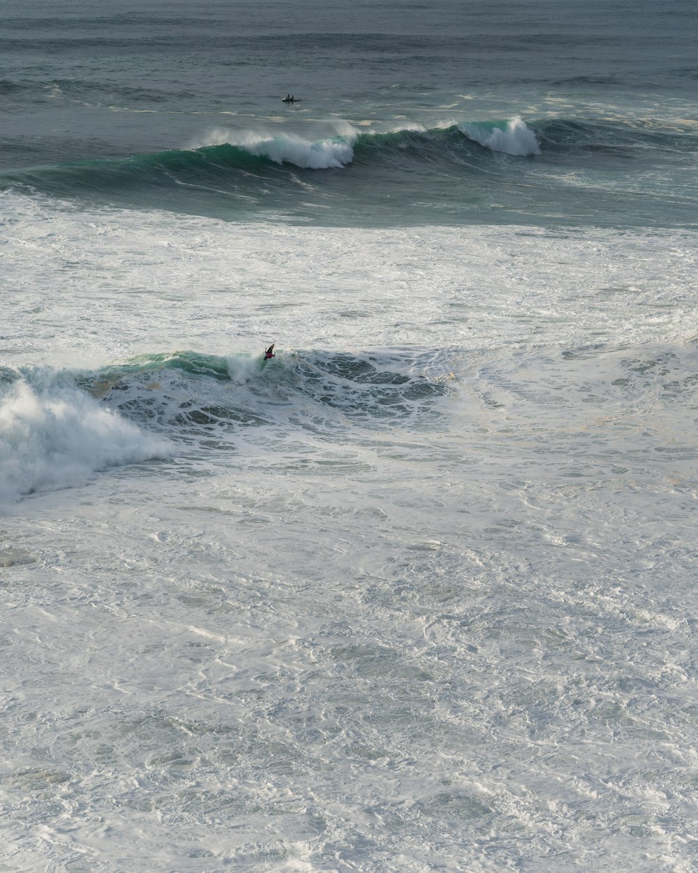 una persona montando una tabla de surf en una ola en el océano