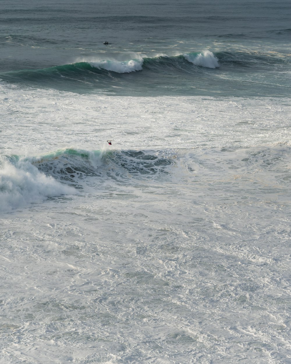海の波にサーフボードを乗せる人