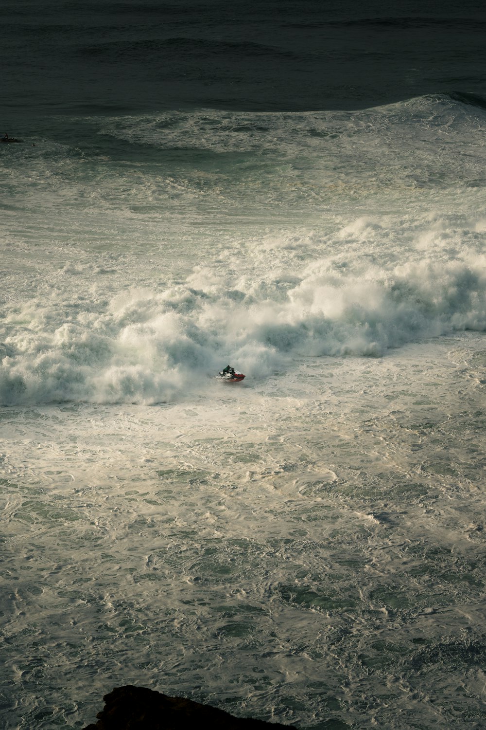 una persona montando una tabla de surf en una ola en el océano