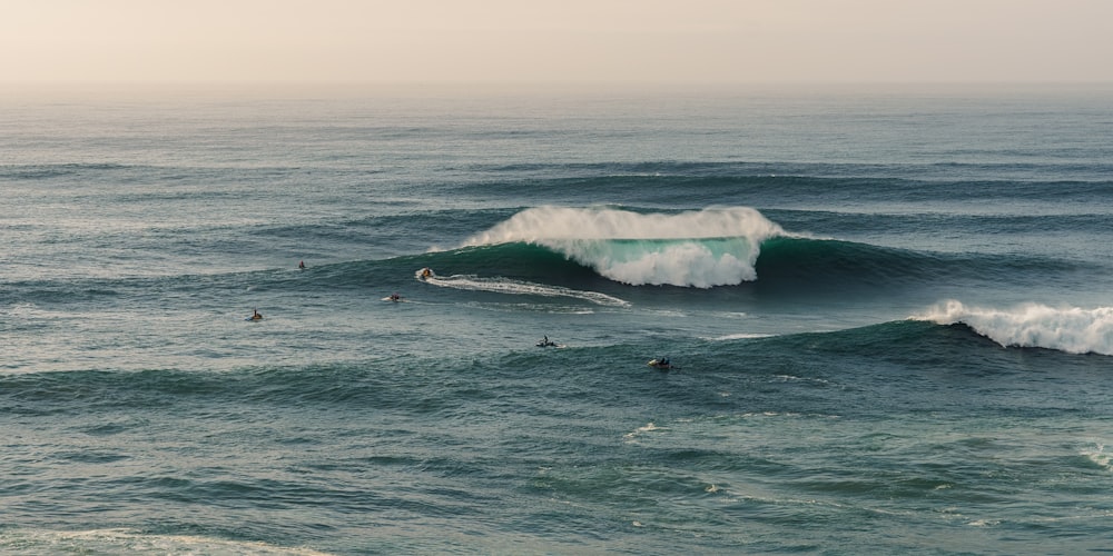 a group of surfers riding a wave in the ocean