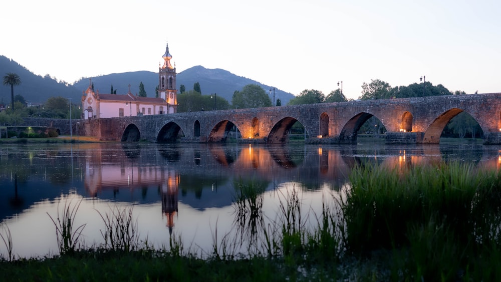 a bridge over a body of water with a church in the background