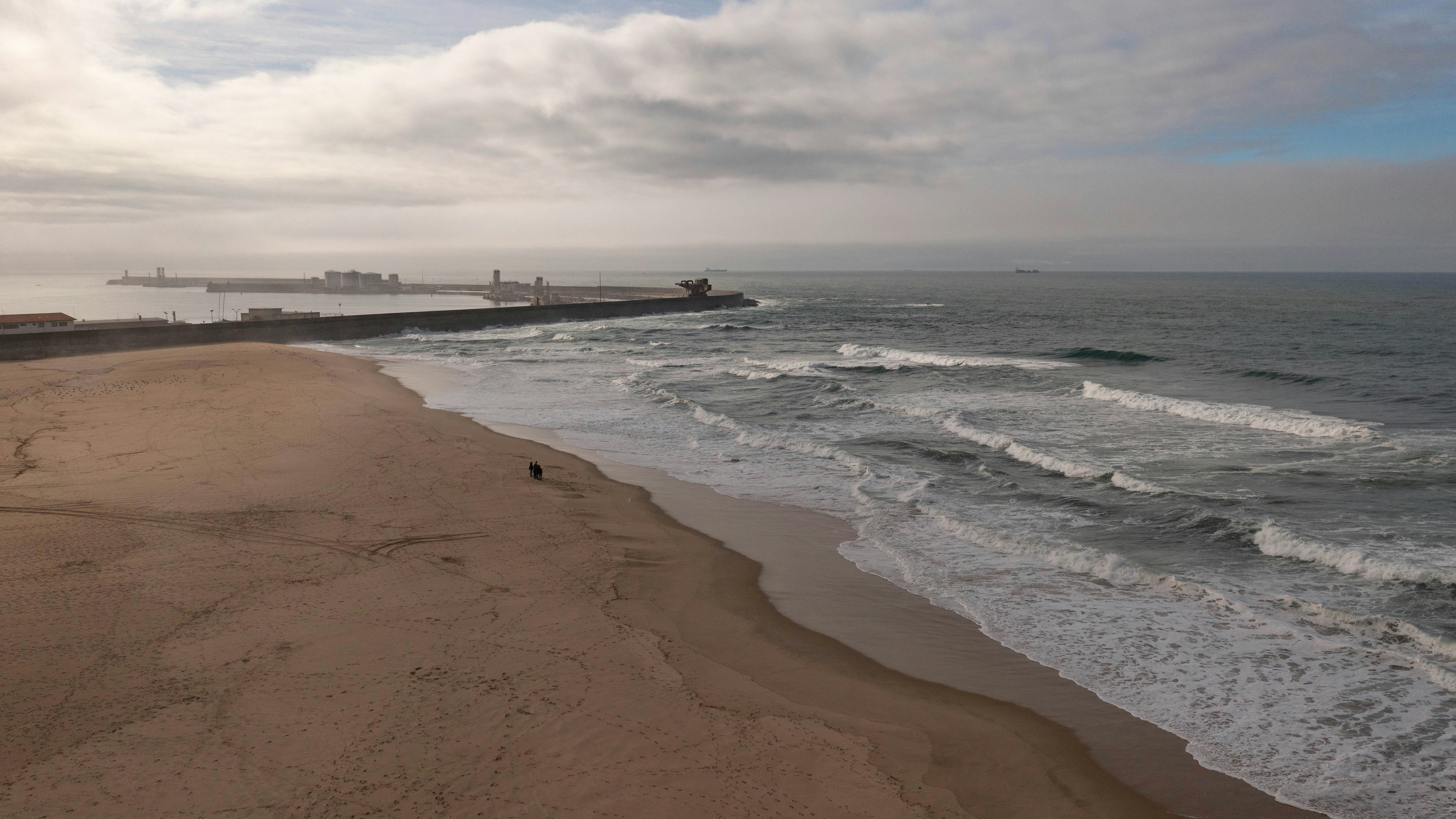 uma praia de areia com ondas chegando à costa