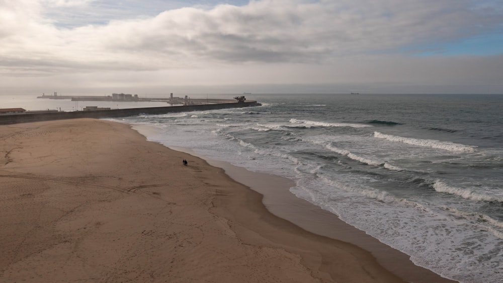 a sandy beach with waves coming in to shore