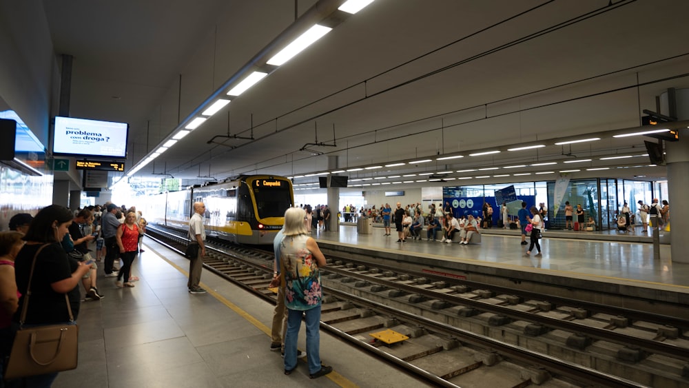 a group of people waiting for a train at a train station