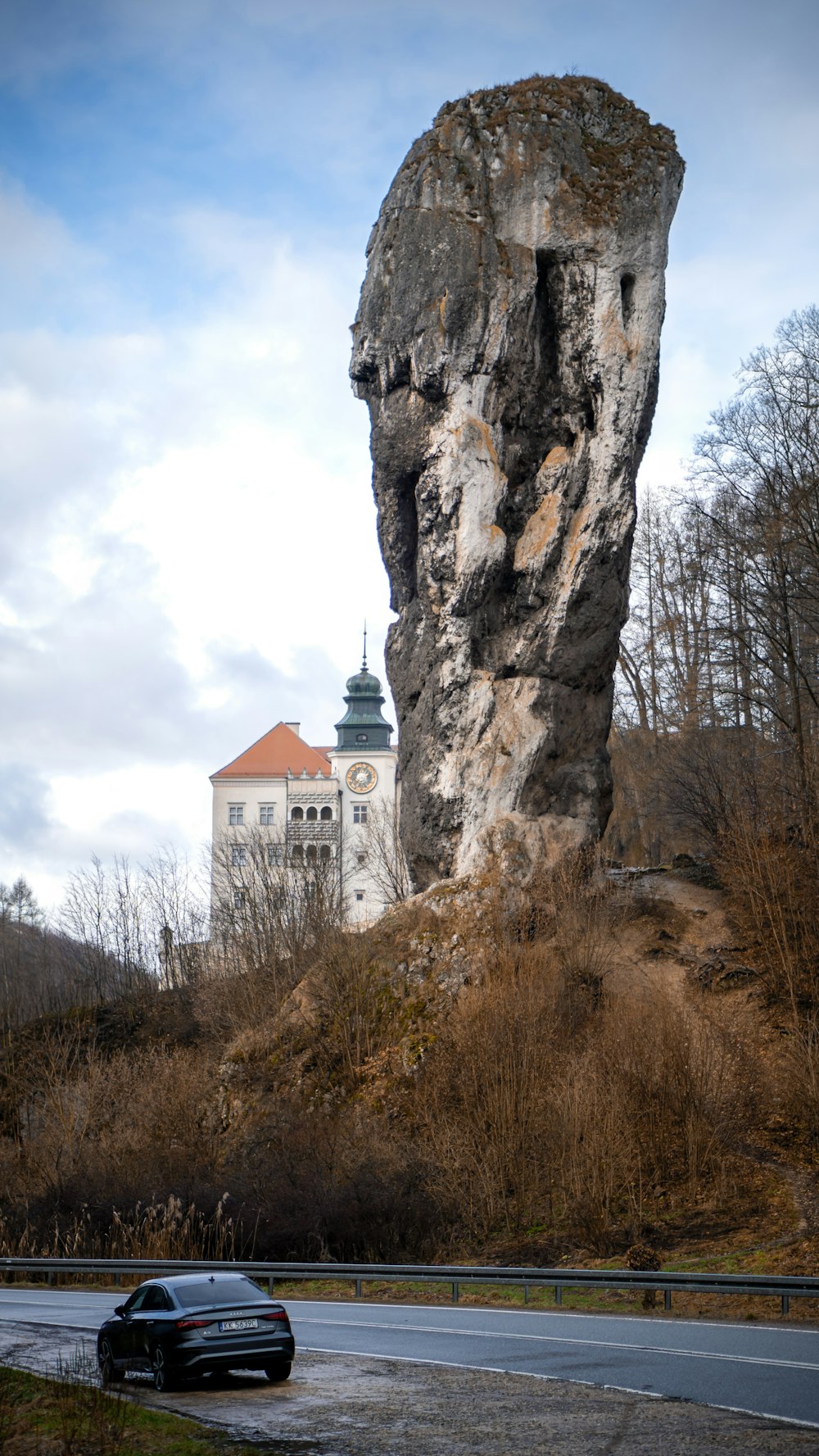 a car driving past a large rock formation