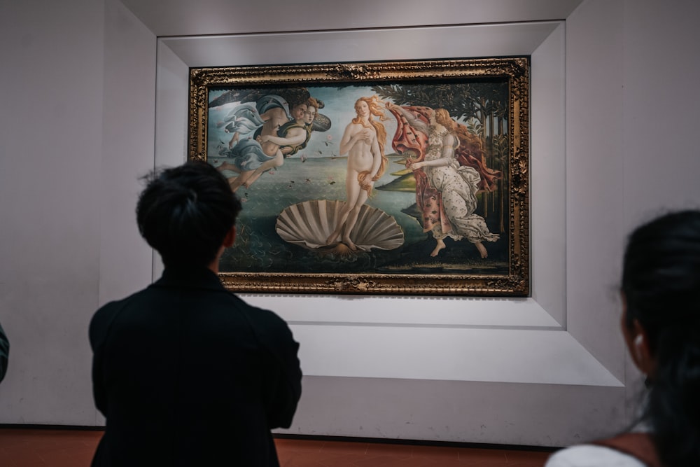 a woman looking at a painting in a museum