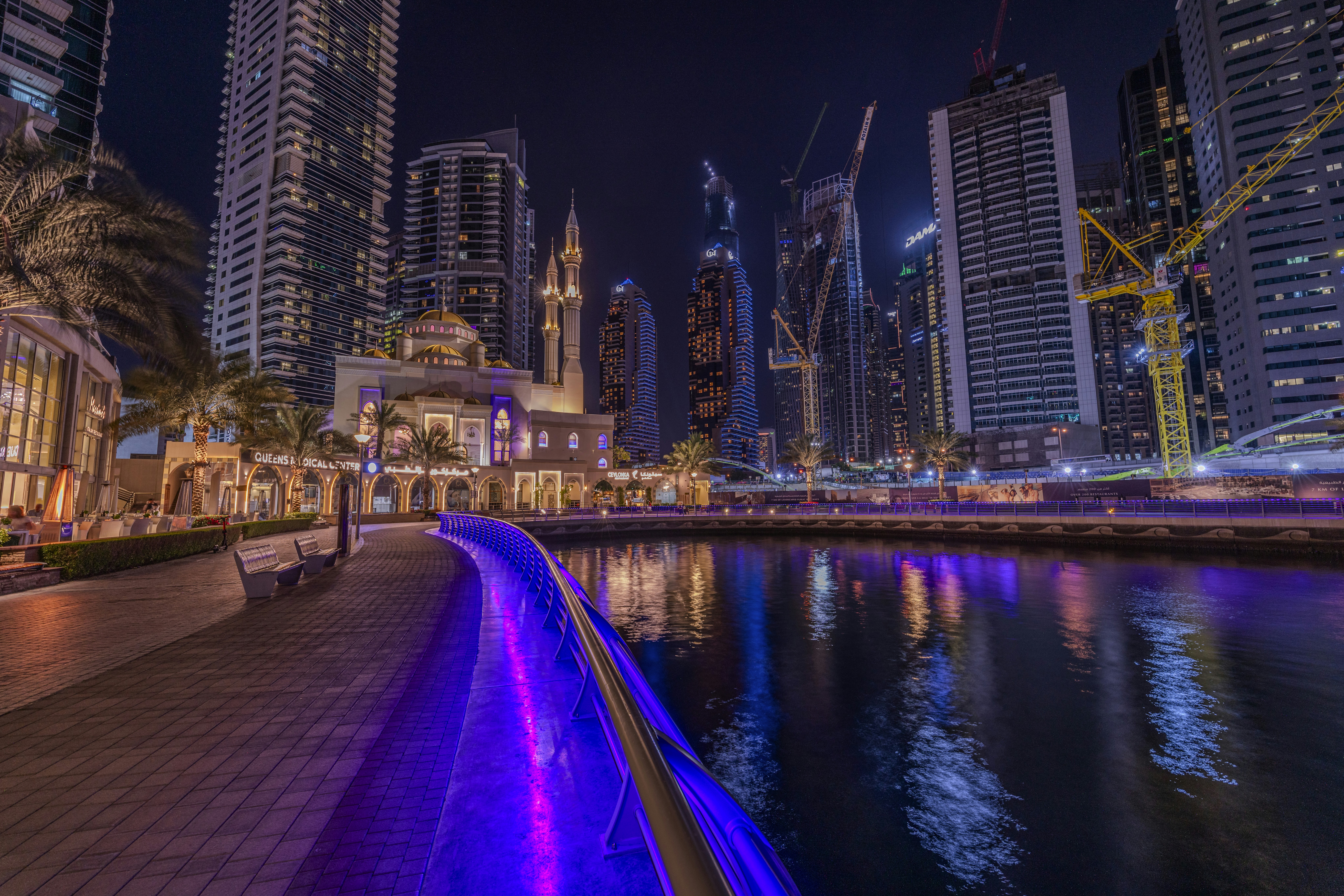 a city at night with lights reflecting in the water