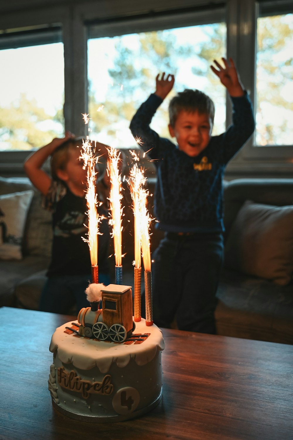 Un niño y una niña de pie frente a un pastel de cumpleaños