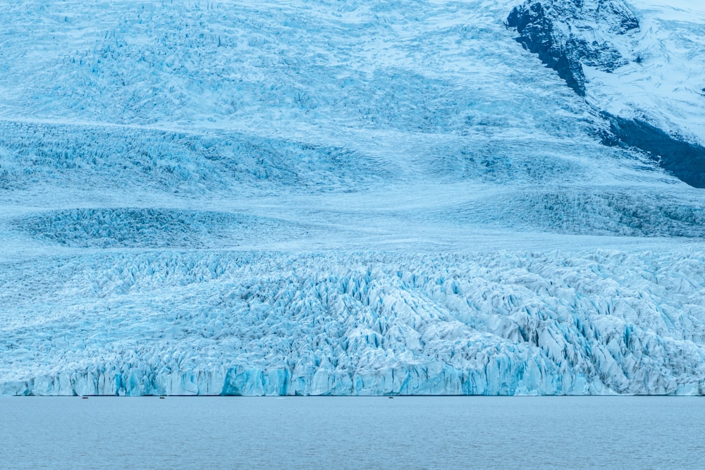 a group of people on a boat in front of a glacier