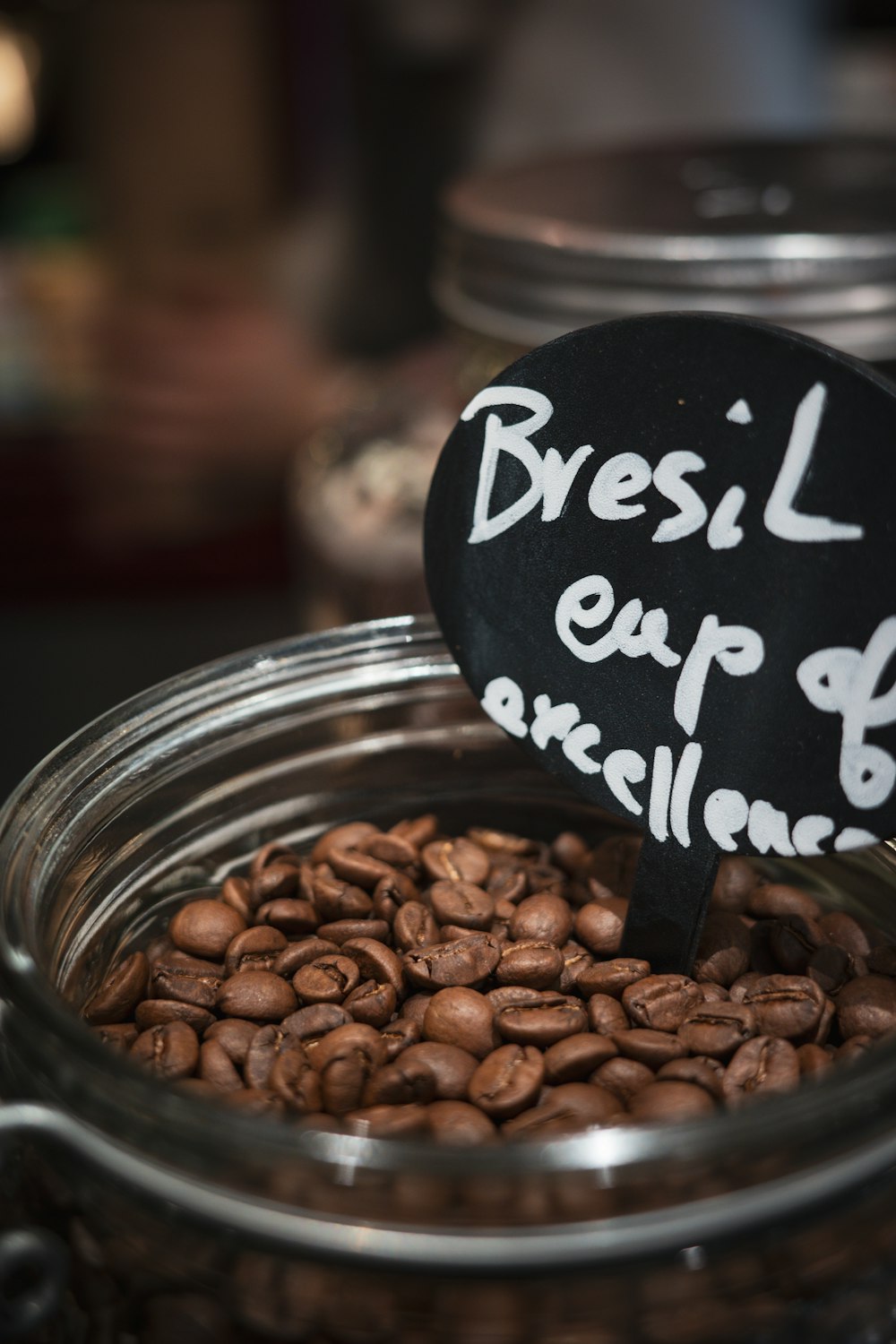 a glass jar filled with coffee beans and a sign