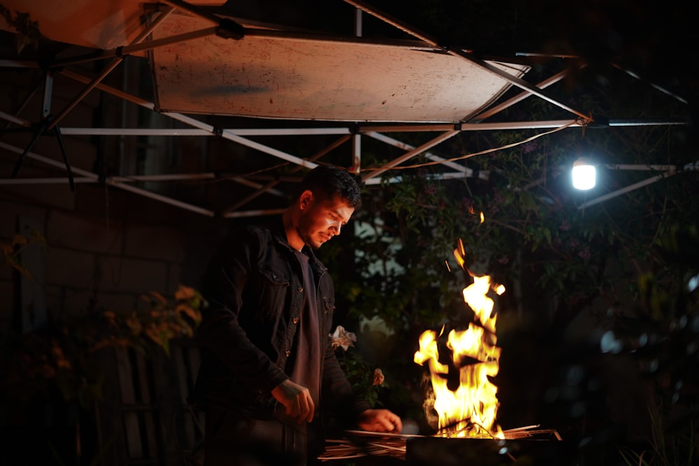 a man standing in front of a fire pit