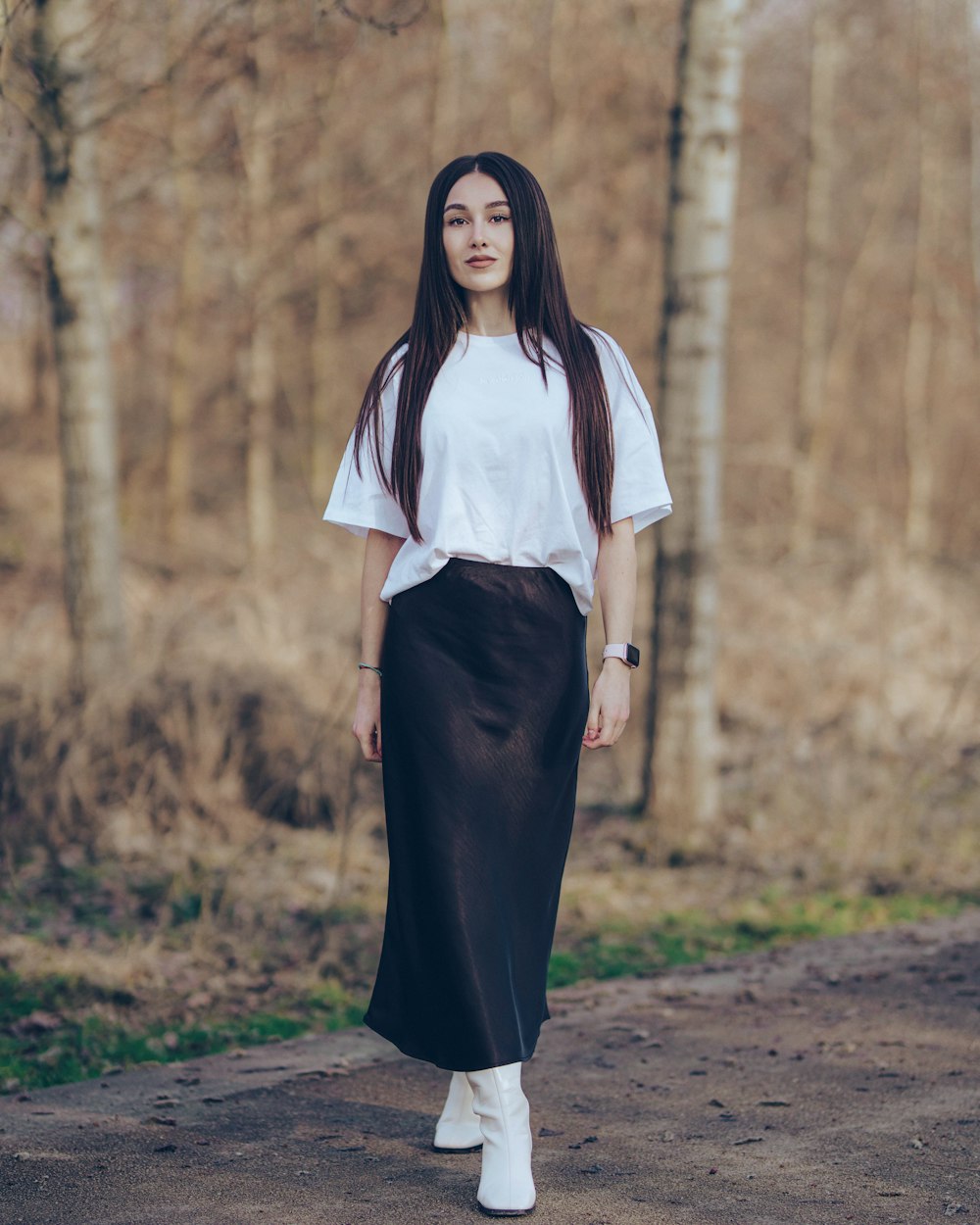 a woman with long hair wearing a white shirt and black skirt