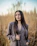 a woman standing in a field of tall grass