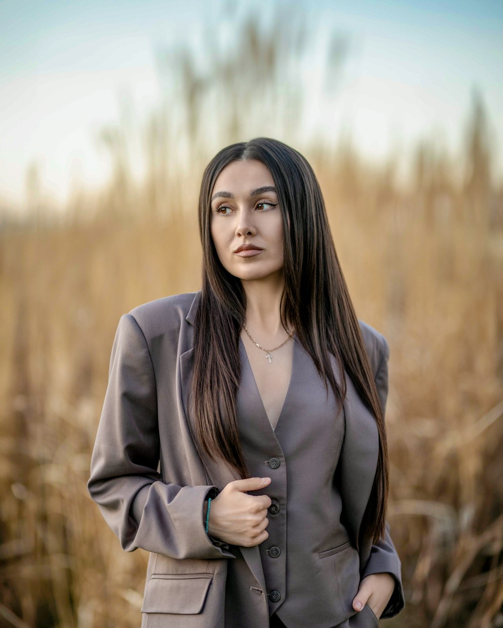 a woman standing in a field of tall grass