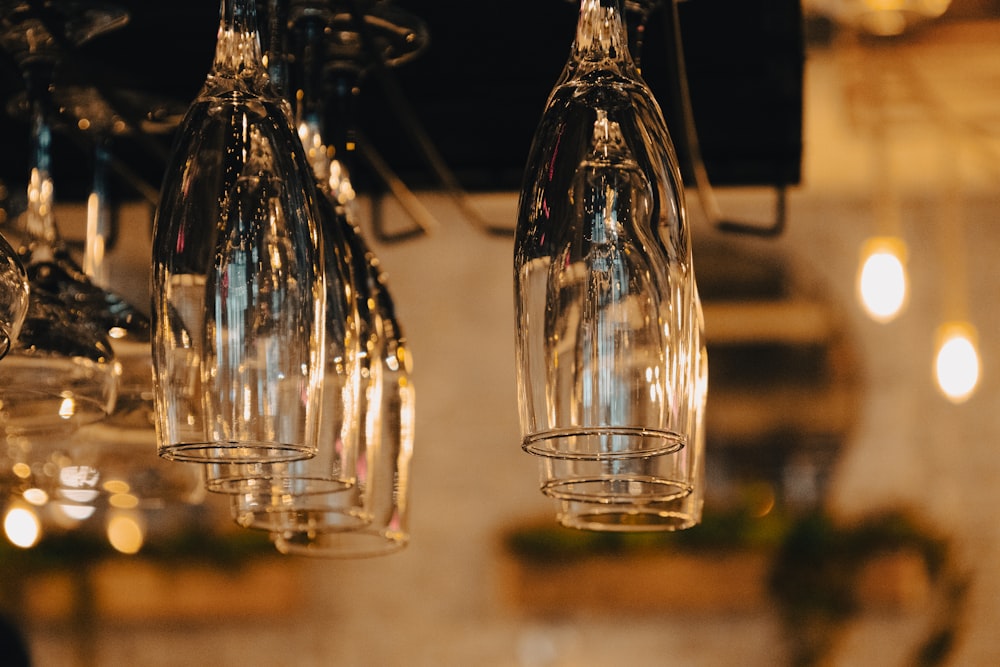 a bunch of wine glasses hanging from a ceiling