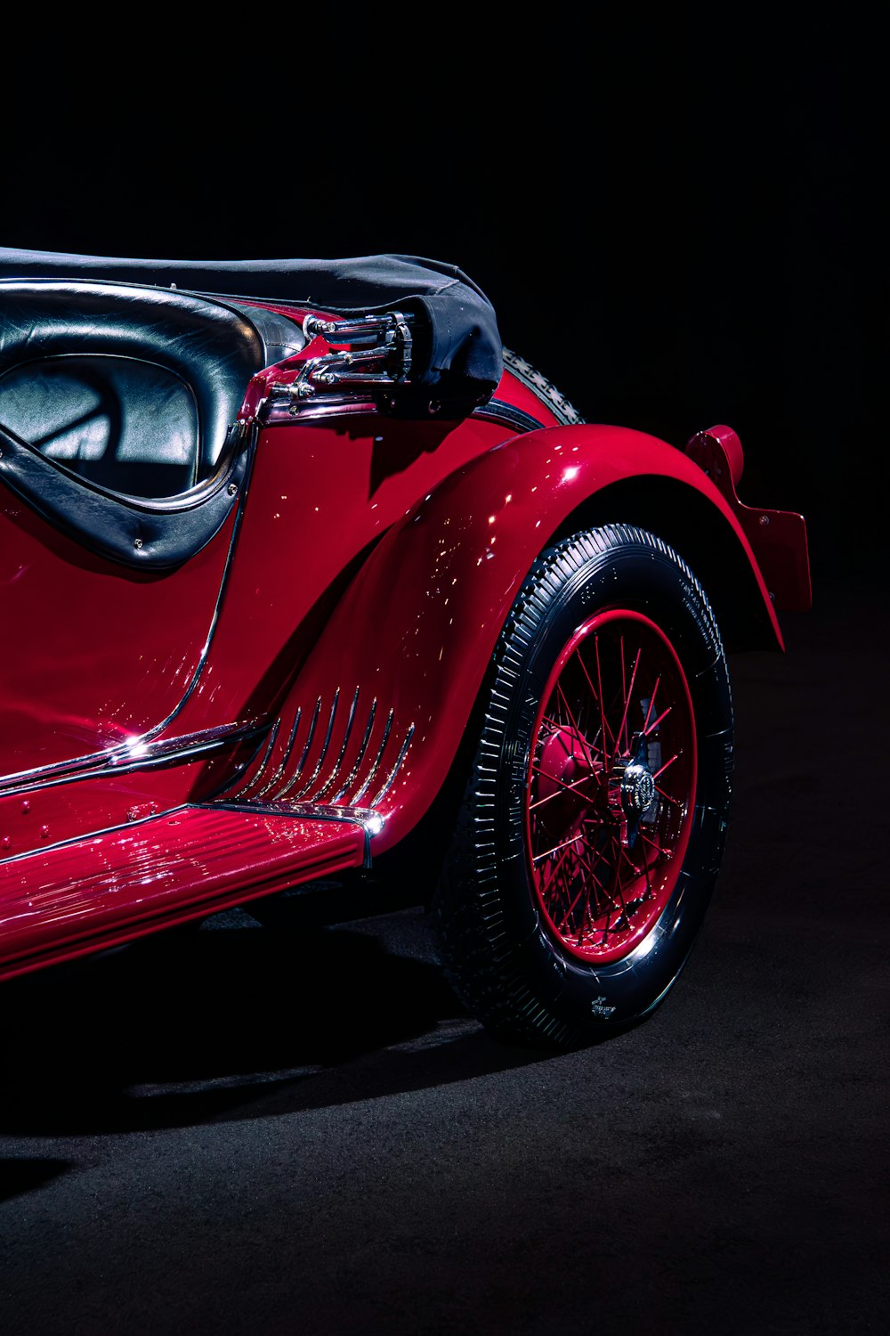 a close up of a red car on a black background