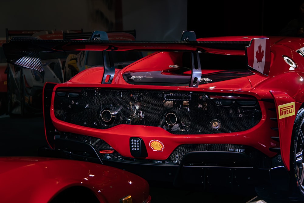 a close up of a red sports car on display