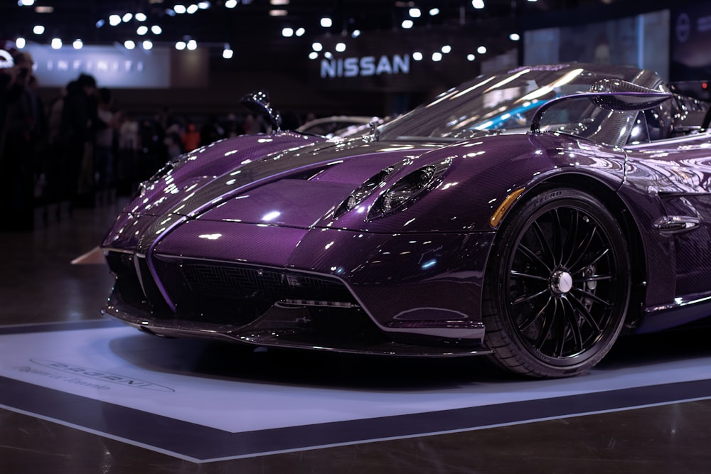 a purple sports car on display at a car show