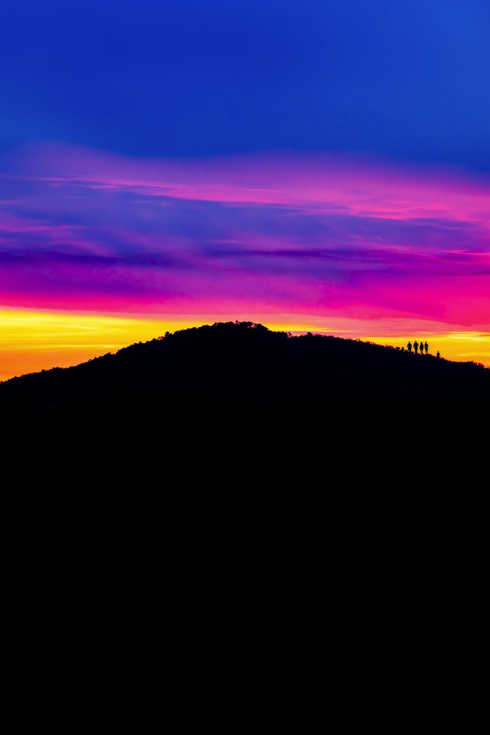 a colorful sky with a mountain in the background