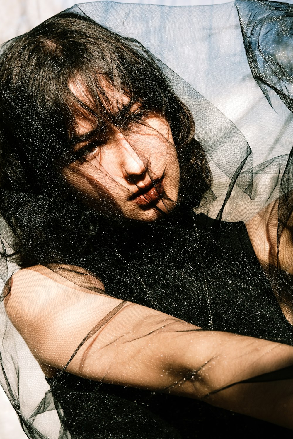 a woman laying on top of a bed covered in sheer fabric