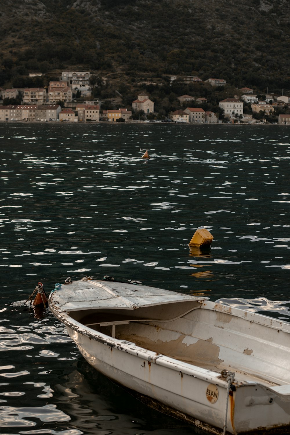 a small white boat floating on top of a lake