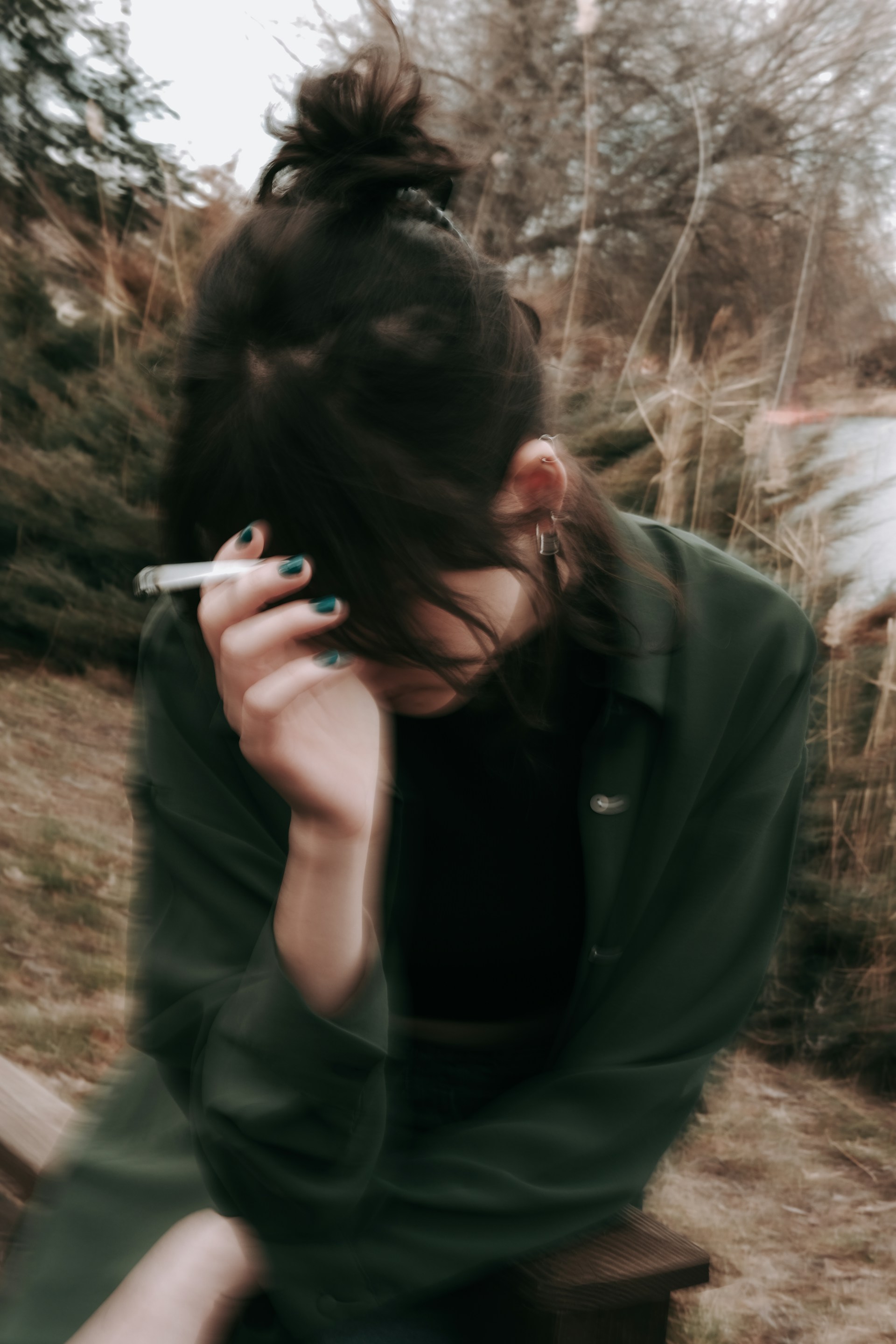 a woman sitting on a bench smoking a cigarette