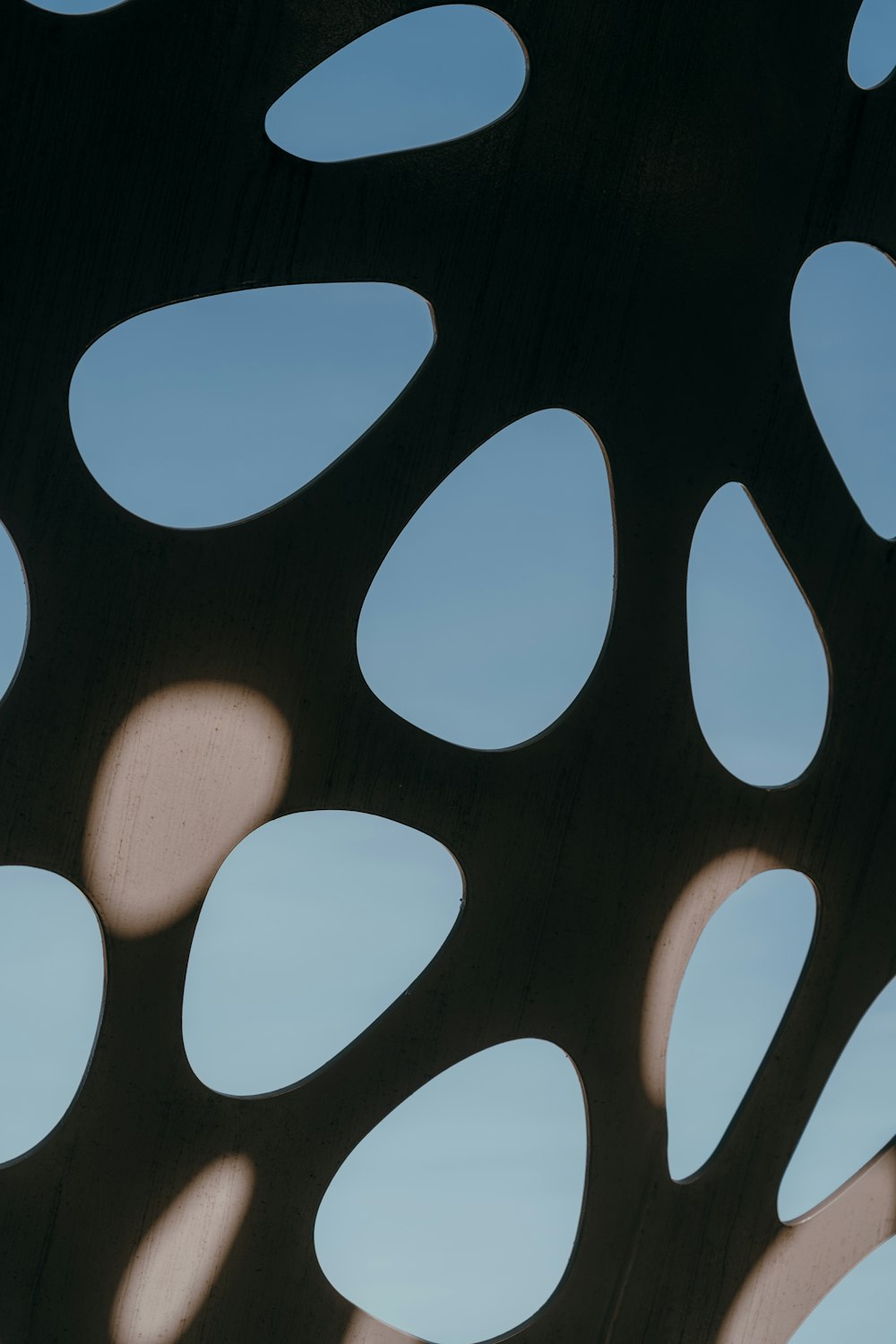 a close up of a metal structure with many circular holes
