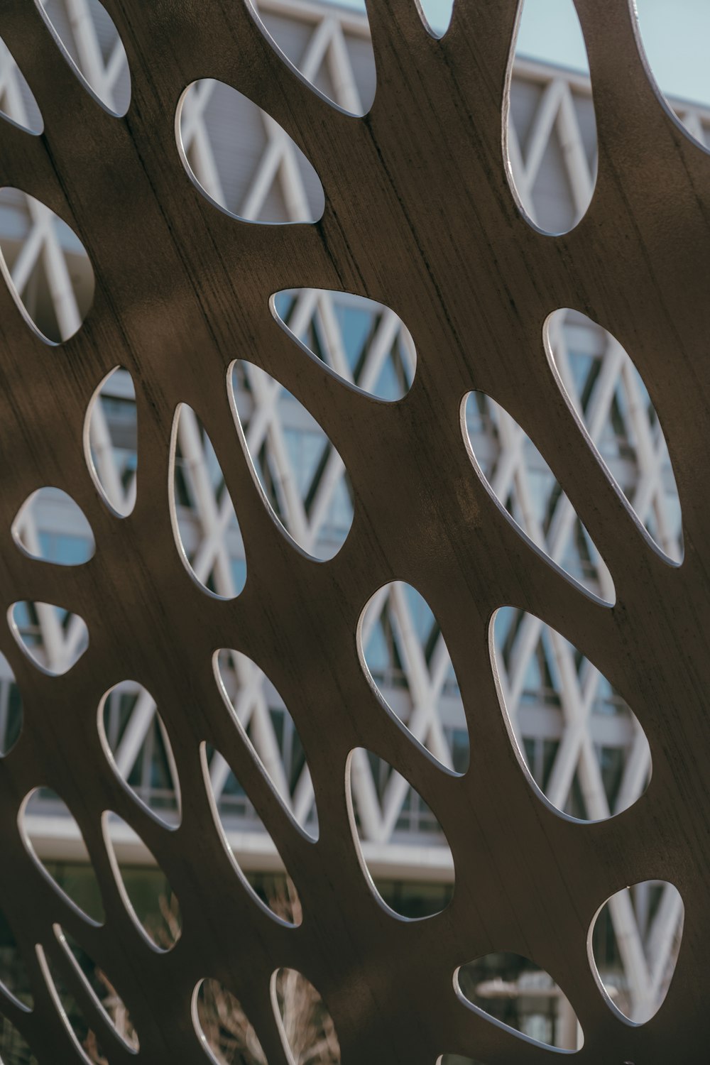 a close up of a metal structure with a building in the background