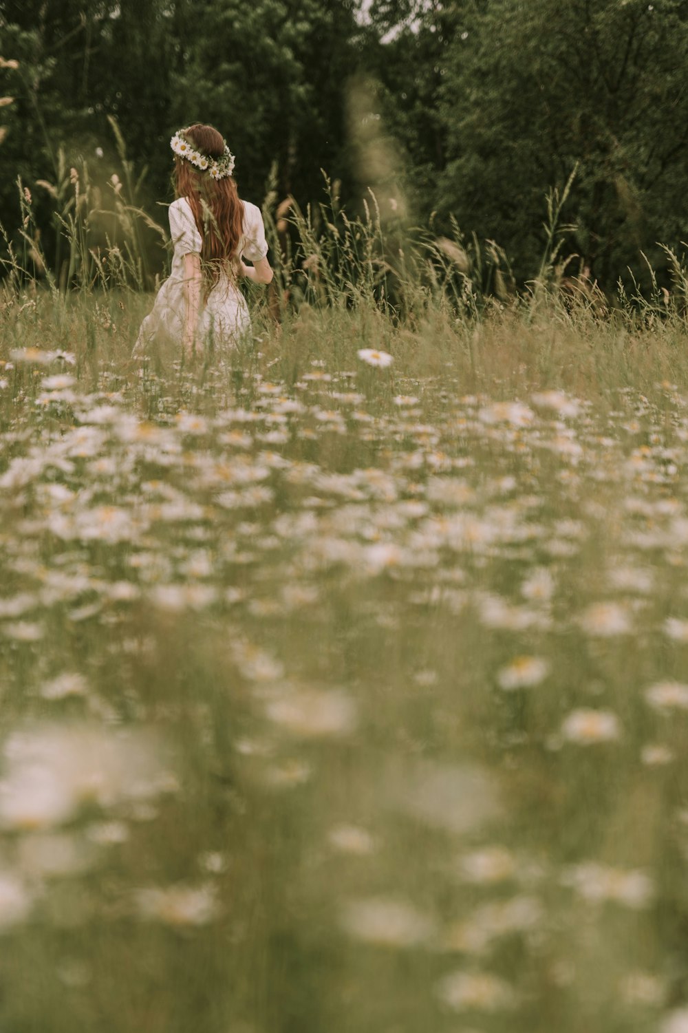 a woman standing in a field of tall grass