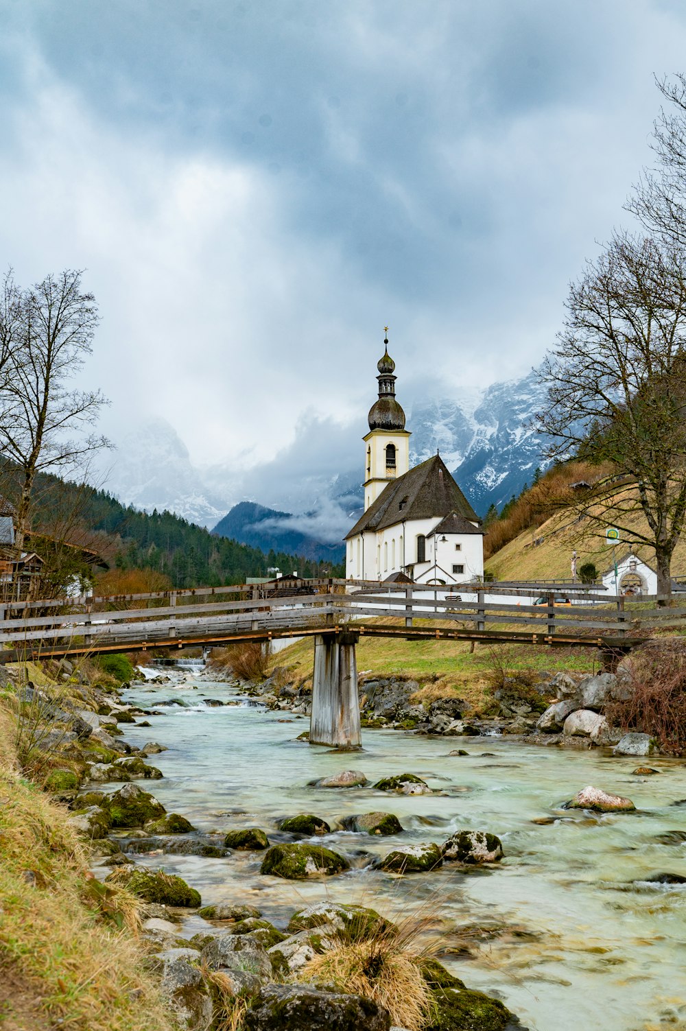 a small church on a bridge over a stream