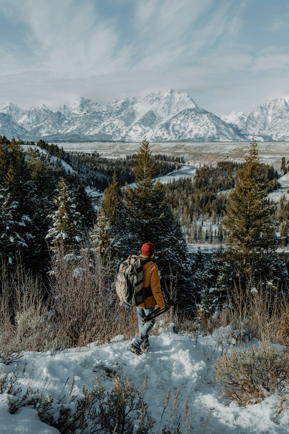 a man with a backpack walking up a snowy hill