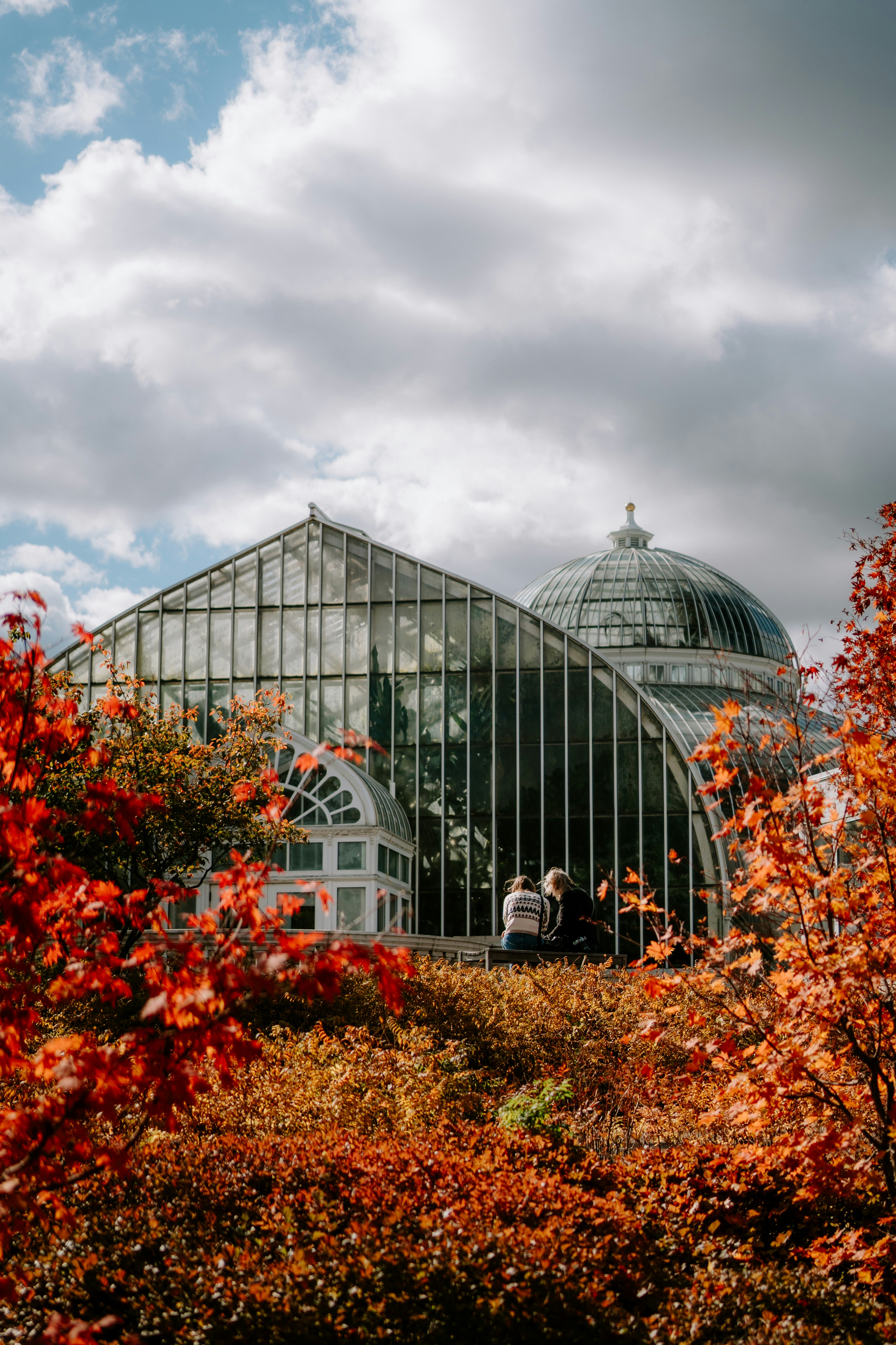 유리 건물 앞에 서 있는 두 사람